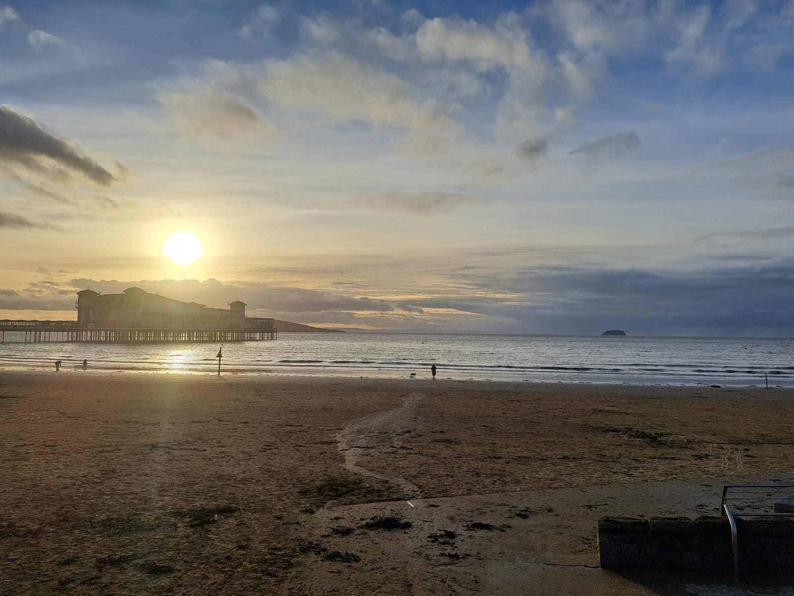 Sunset over a beach and pier, calm after the storm